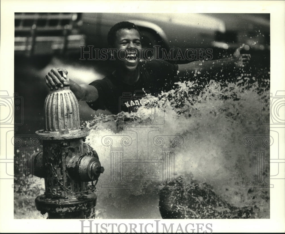 1987 Press Photo Poncho Williams cooling off in open fire-hydrant-S. Prieur St - Historic Images