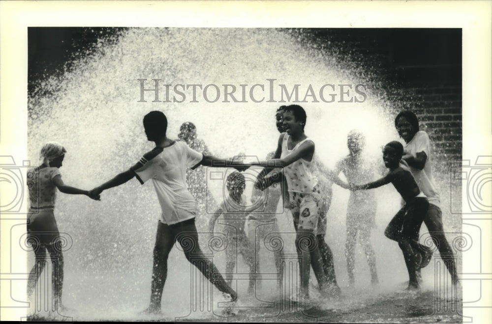 1988 Press Photo Children play near an open fire hydrant on N. Tonti &amp; Dumaine - Historic Images