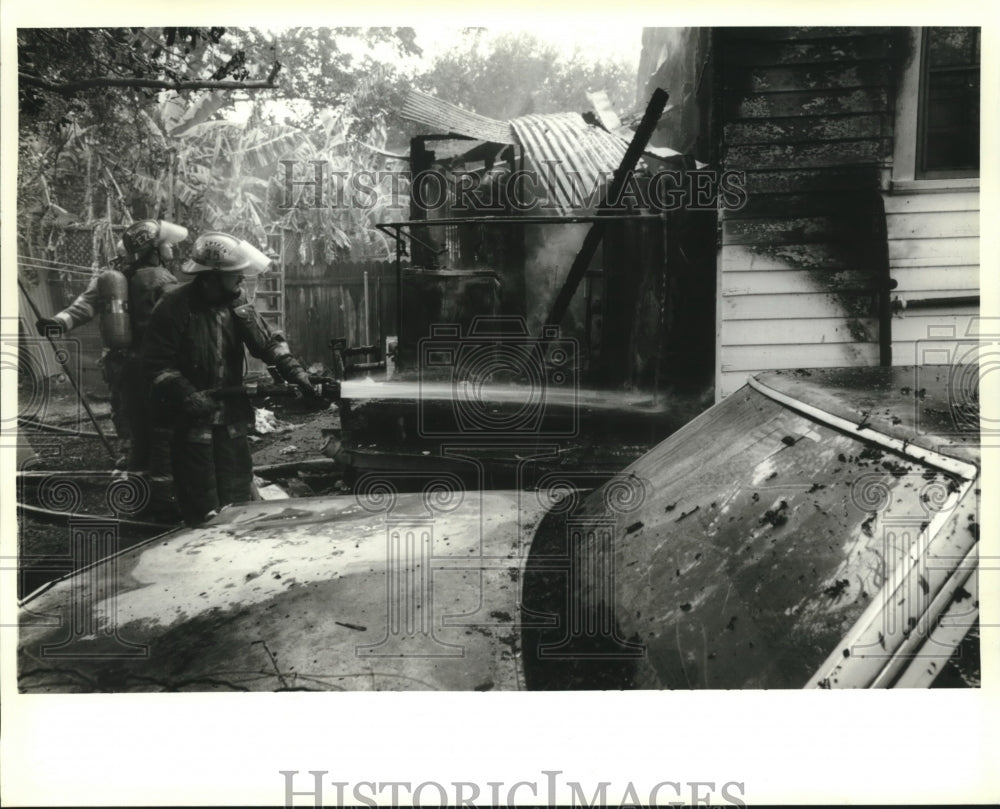 1995 Press Photo New Orleans firefighters hose down rear of house. - Historic Images