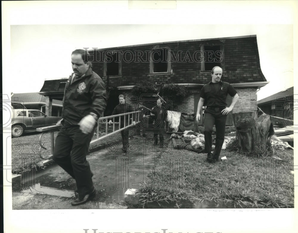 1992 Press Photo Firefighters haul ladder from scene of fatal fire on Dwyer Road - Historic Images