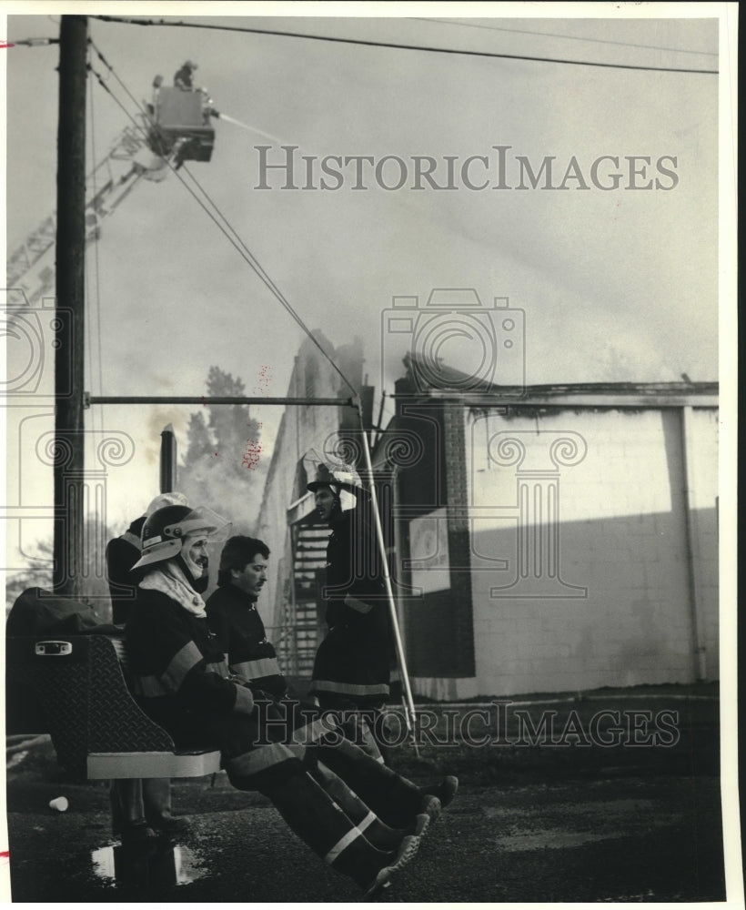 1988 Press Photo Firefighters rest next to burned out building - Historic Images