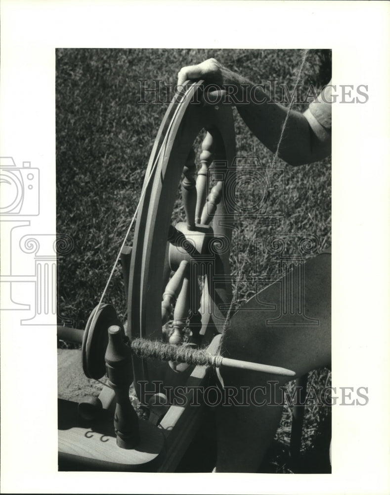 1987 Weaver, Marcia Frank shows off her spinning wheel. - Historic Images