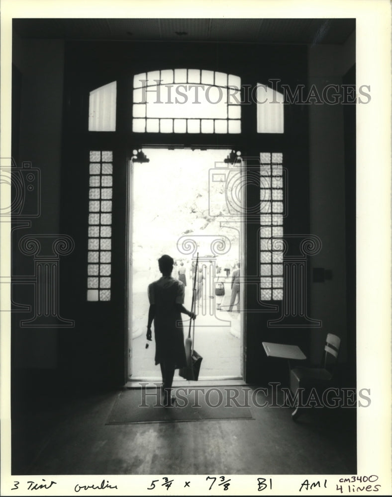 1990 Press Photo Custodian walks through front doors, Franklin Senior High - Historic Images