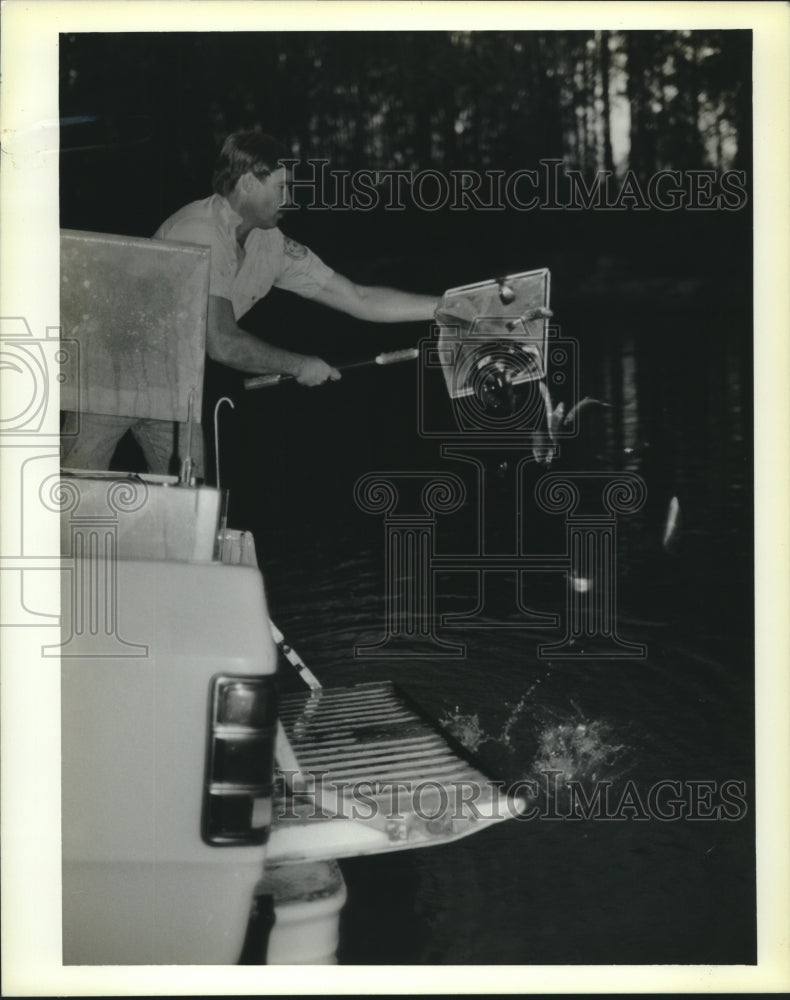 1990 Press Photo Mark Lawson stocks Fritchie Park Pond with rainbow trout. - Historic Images