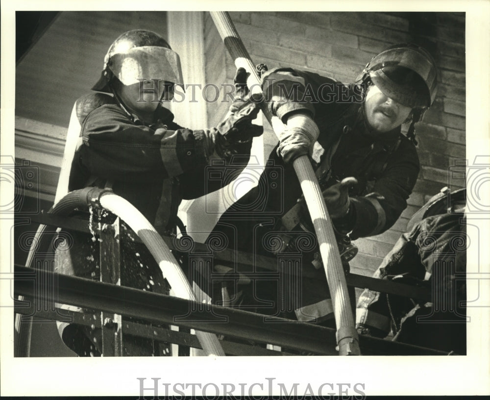 1986 Press Photo Two firefighters fighting a fire at Tulane University - Historic Images