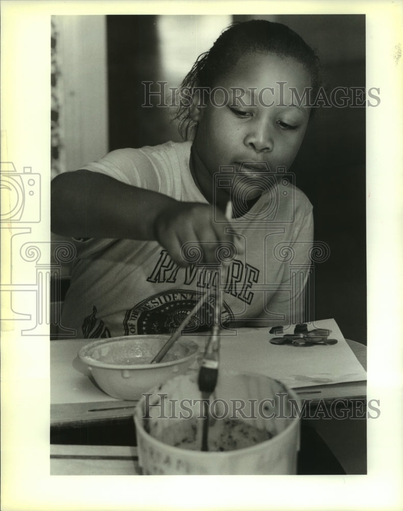 1989 Press Photo Glenna Gauthier puts paint on her brush at Marie Riviere School - Historic Images