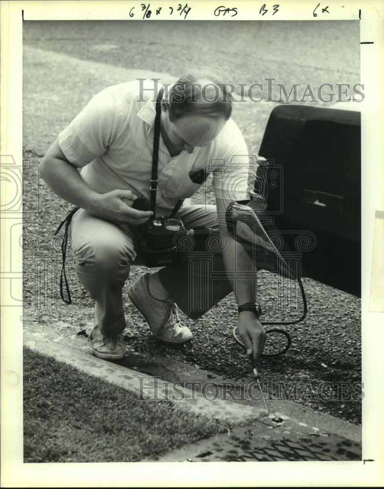 1991 Press Photo Joe Musso, DEQ, tests for gasoline vapors in an Exxon drain - Historic Images