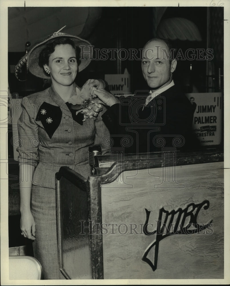 1957 Press Photo Mrs. Charles Ganucheau receives an orchid from Harry Cabral - Historic Images