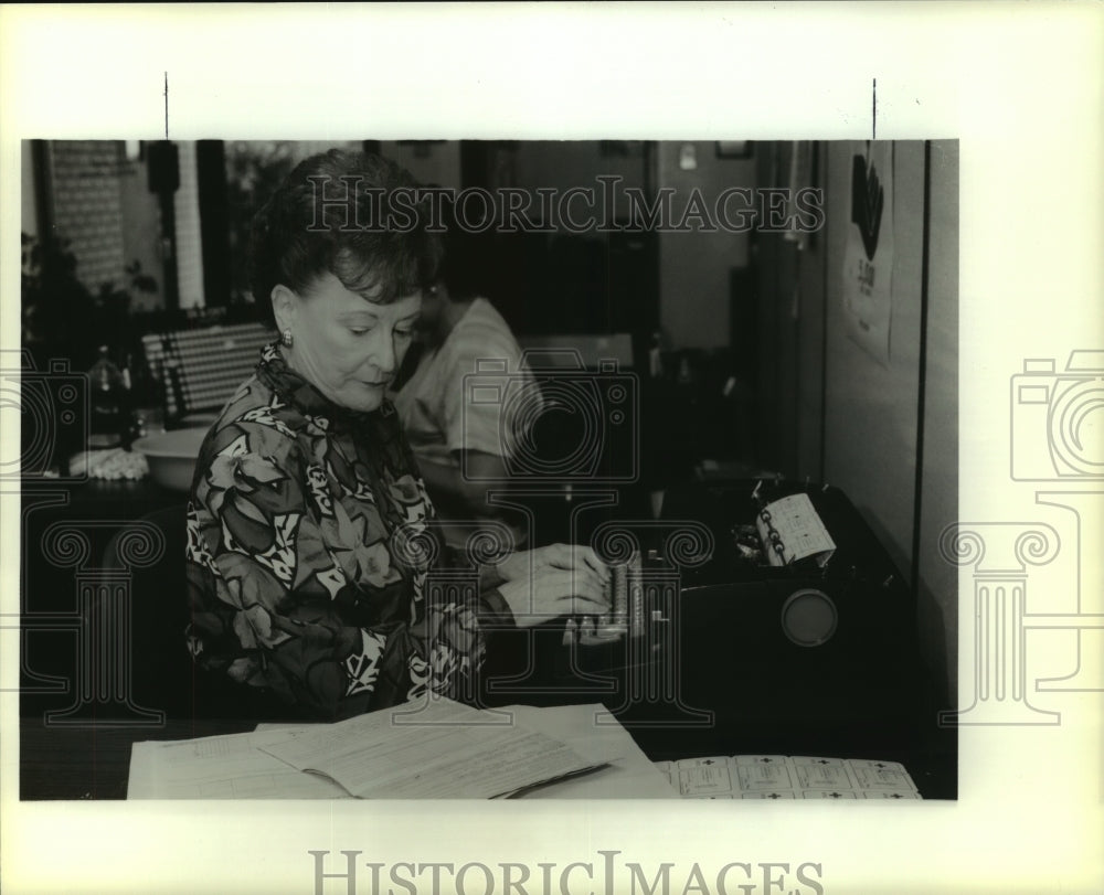 1990 Press Photo Muriel Gaulon types Red Cross identification cards. - Historic Images