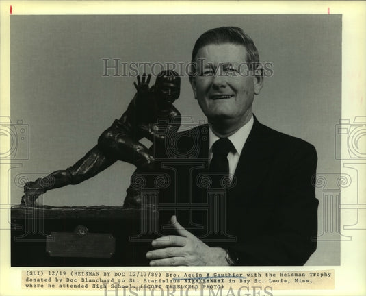 1989 Press Photo Aquin Gauthier holds Doc Blanchard's Heisman Trophy - Historic Images