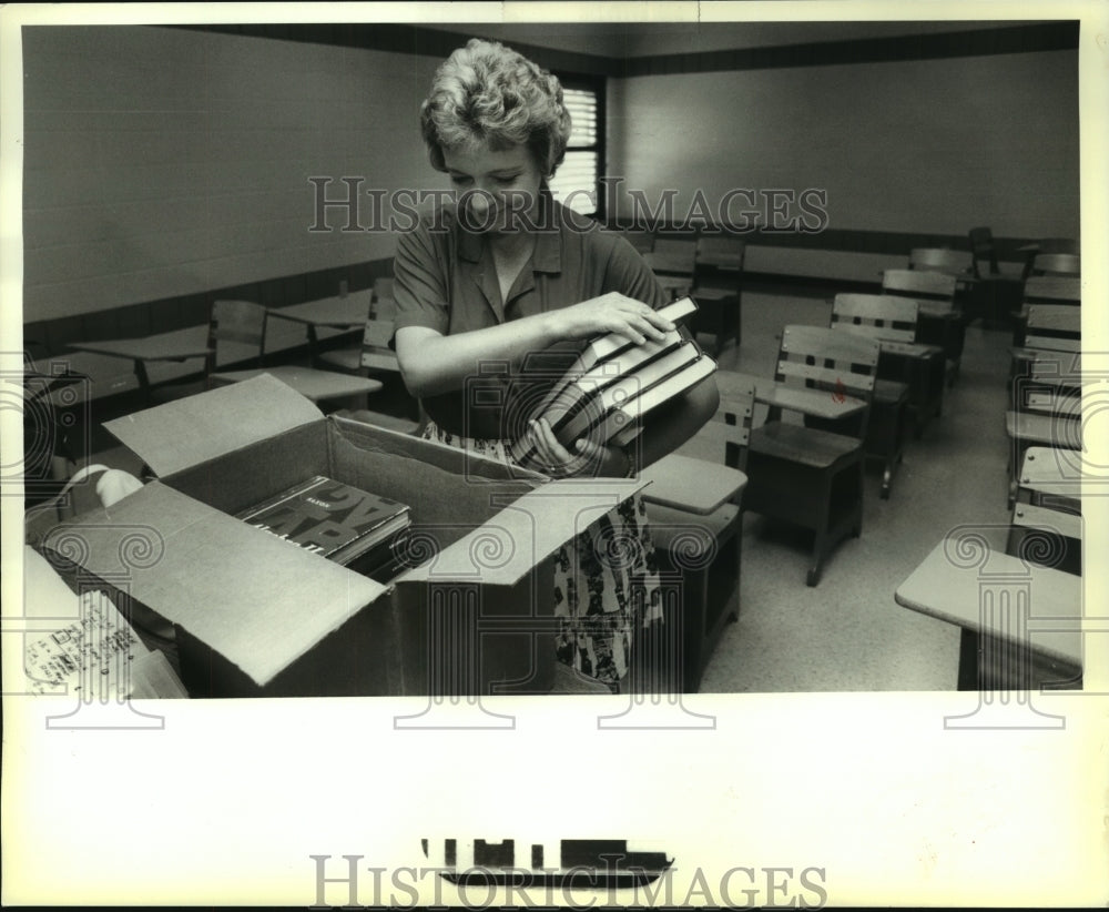 1989 Press Photo Teacher Dianne Gauthier unpacks Algebra II books in classroom - Historic Images