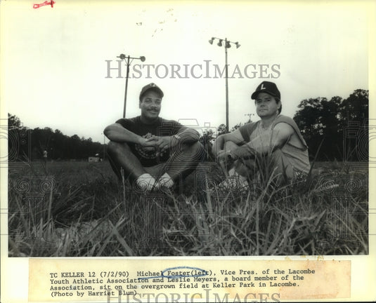 1990 Press Photo Michael Foster & Leslie Meyers sit on overgrown Keller Field - Historic Images