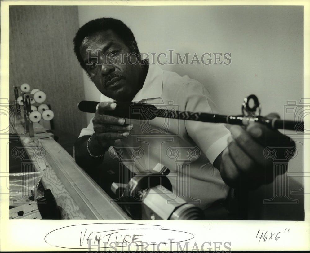 1988 Press Photo Hugh Foster eyes one of his fishing rod creations. - Historic Images