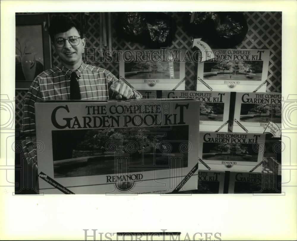 1990 Press Photo Bruce Aronson holds up garden pool kit at Pool and Patio store - Historic Images