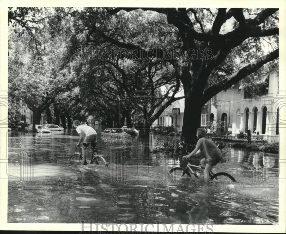 1991 Press Photo Two youngsters biking on a flooded street - nob19409 - Historic Images