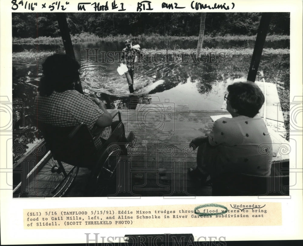 1991 Press Photo Eddie Mixon trudges through flood waters east of Slidell - Historic Images