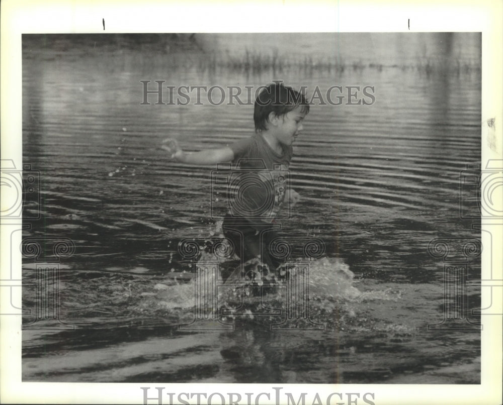 1994 Press Photo Stephan Russell plays in the high water in his front yard. - Historic Images