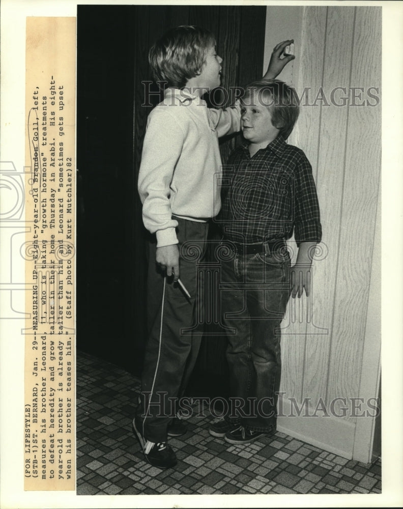 1982 Press Photo Brandon Goll measures his brother Leonard in their Arabi home - Historic Images