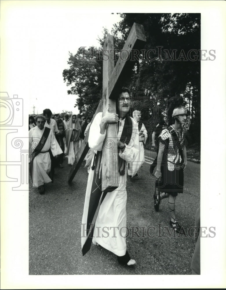 1991 Press Photo Catholic church pastor carries cross in Good Friday reenactment - Historic Images