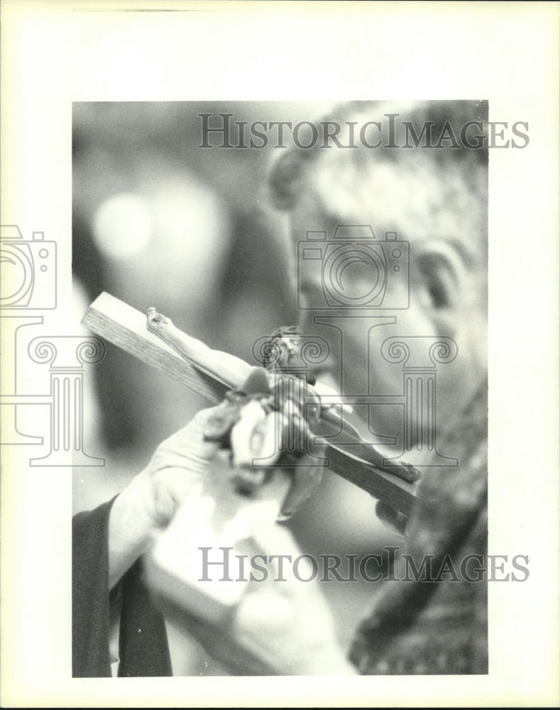 1995 Press Photo Catholic priest kisses the Cross during Good Friday service - Historic Images