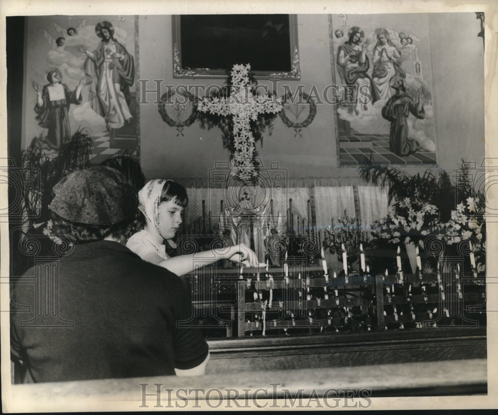 1960 Press Photo Parishioner lighting a candle during Good Friday observances - Historic Images