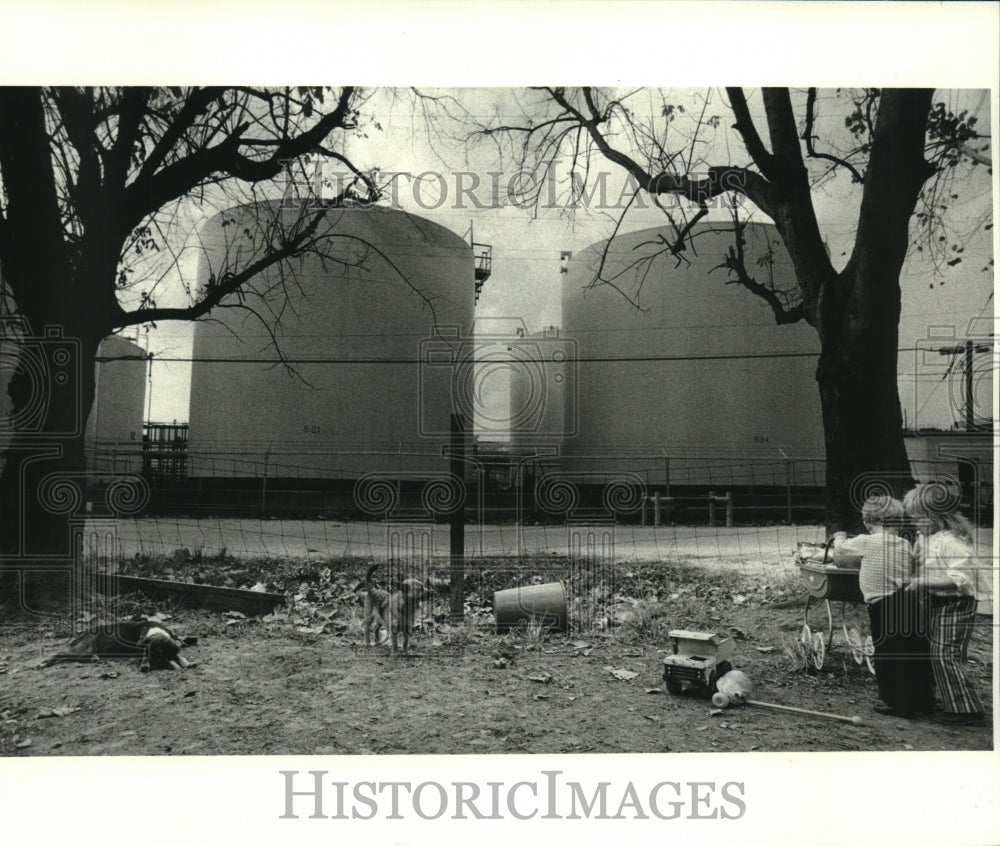 1980 Press Photo Two children at play with Good Hope storage tanks in background - Historic Images