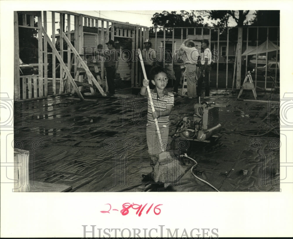 1989 Press Photo Five-year old Joel Gonzalez sweeps water off Wilson Home - Historic Images