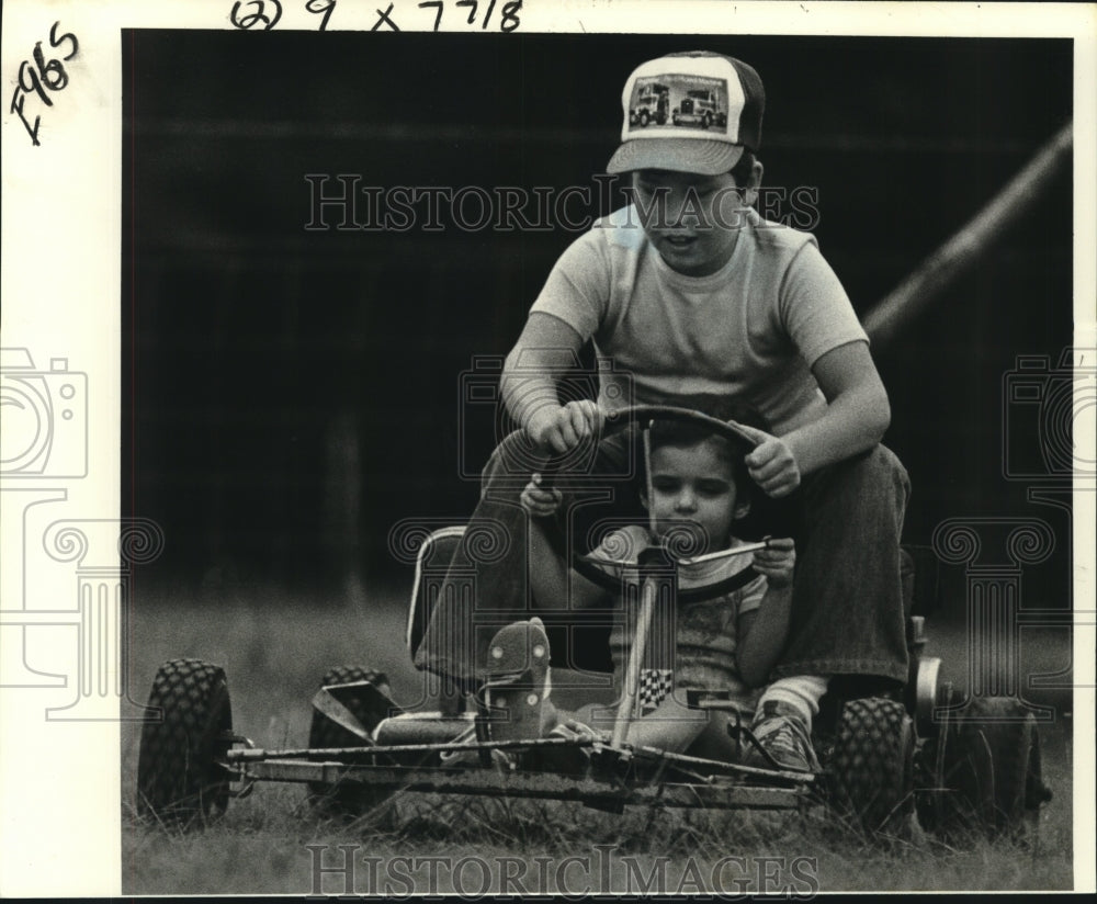 1980 Press Photo Tiffany Truett helped by brother Jamie with steering go-cart - Historic Images