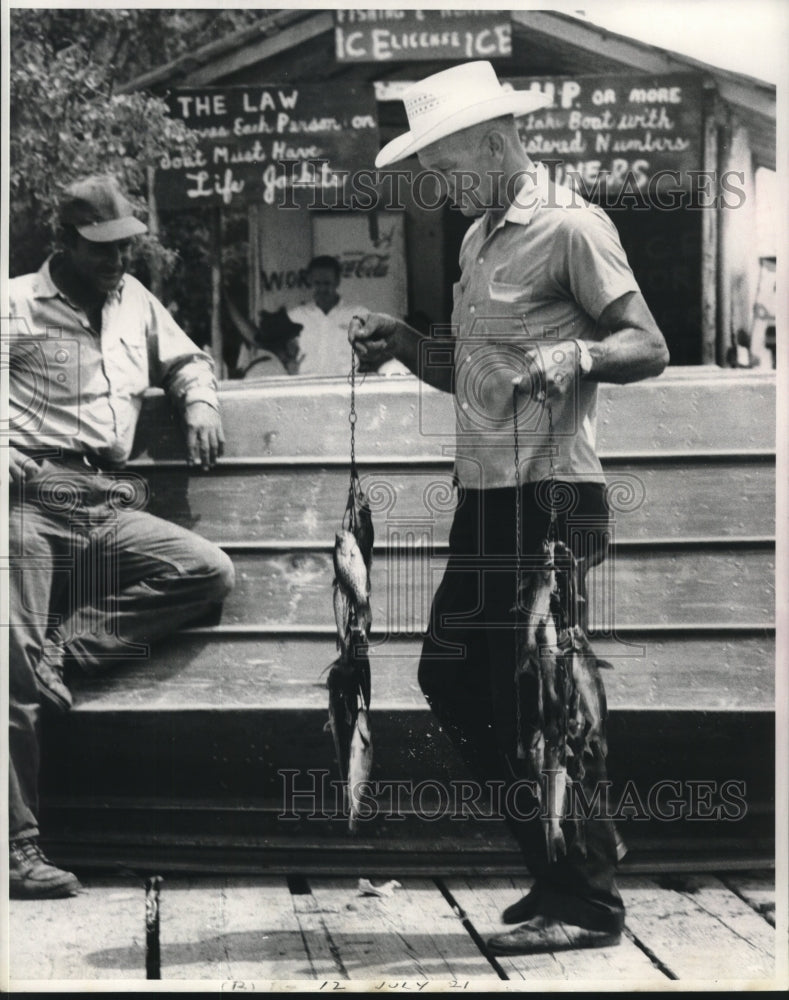 Press Photo Ray Fonseca of Marina on the Bayou eyes customer&#39;s catch - Historic Images