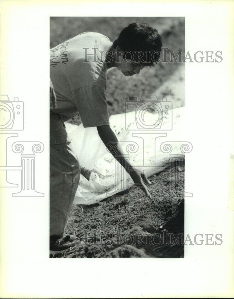 1992 Press Photo &quot;Green Team&quot; member plants pumpkin seeds at Kelvin Landfill - Historic Images