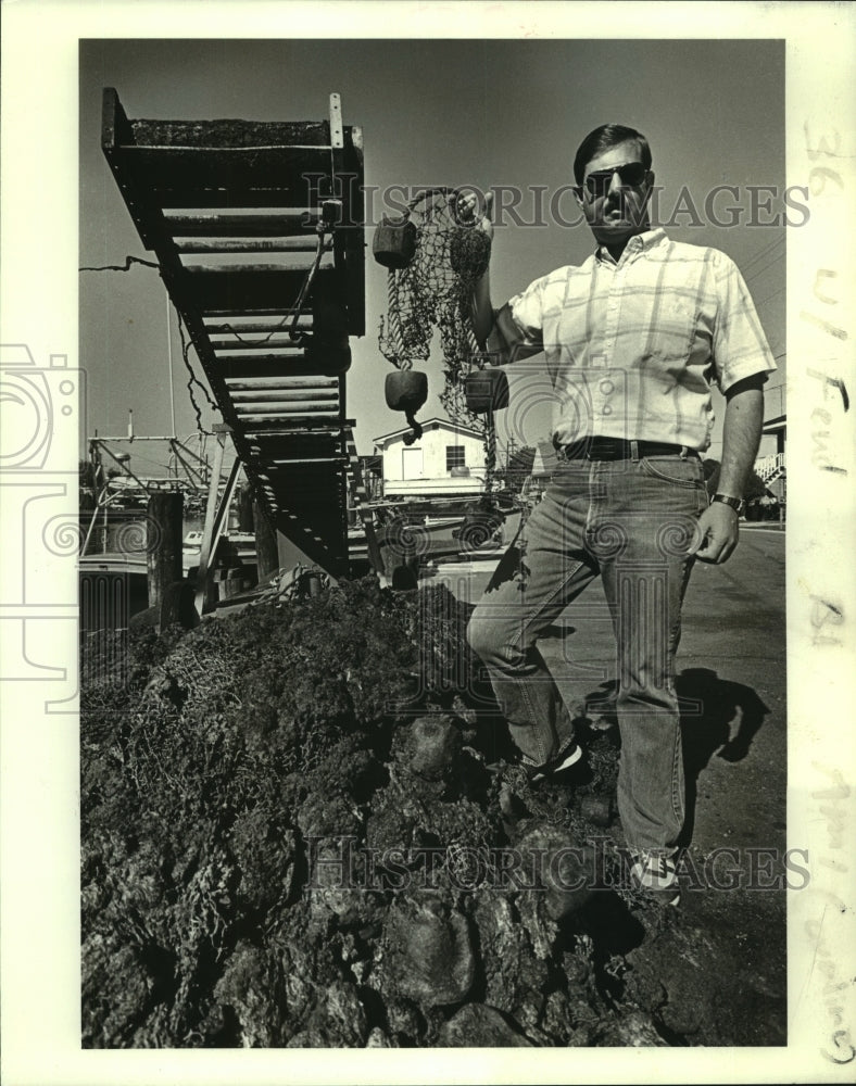 1986 Press Photo Bill Guarino holds a piece of haul sein after fire - nob21718 - Historic Images