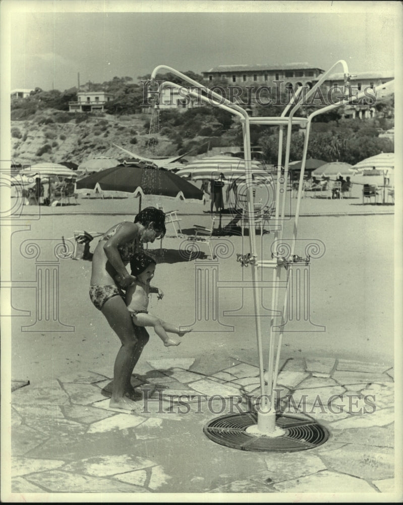 1971 Press Photo A young child and mother take a shower at the Apollo Coast - Historic Images