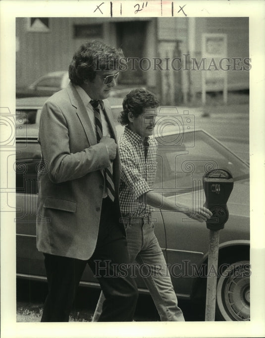 1986 Press Photo Alonzo Guajardo, escorted to a parking to deposit some coins - Historic Images