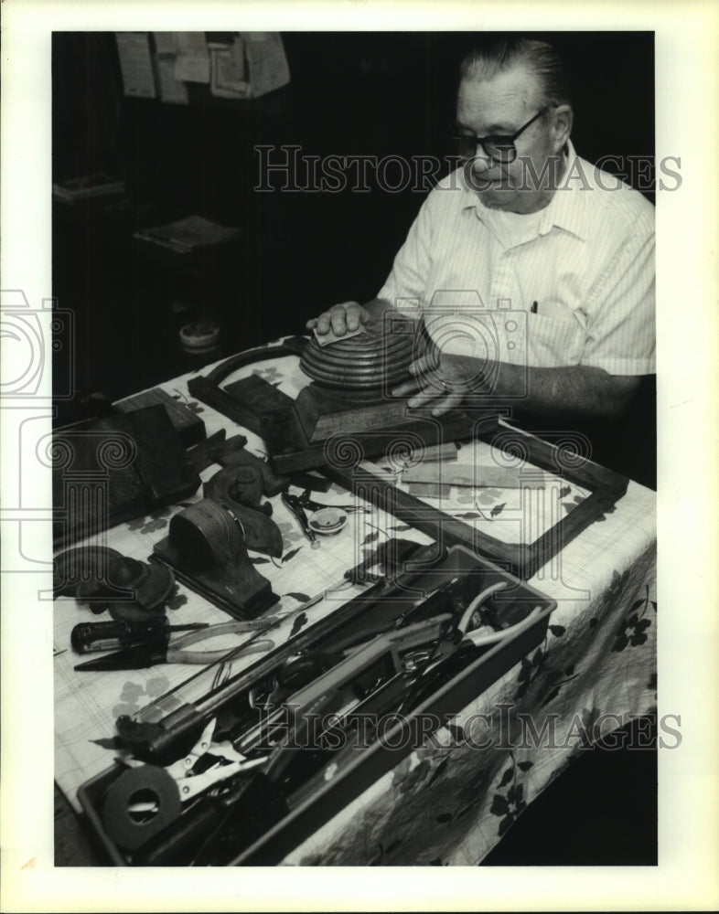 1991 Press Photo Albert Graythe sands on the wood section of an antique clock - Historic Images