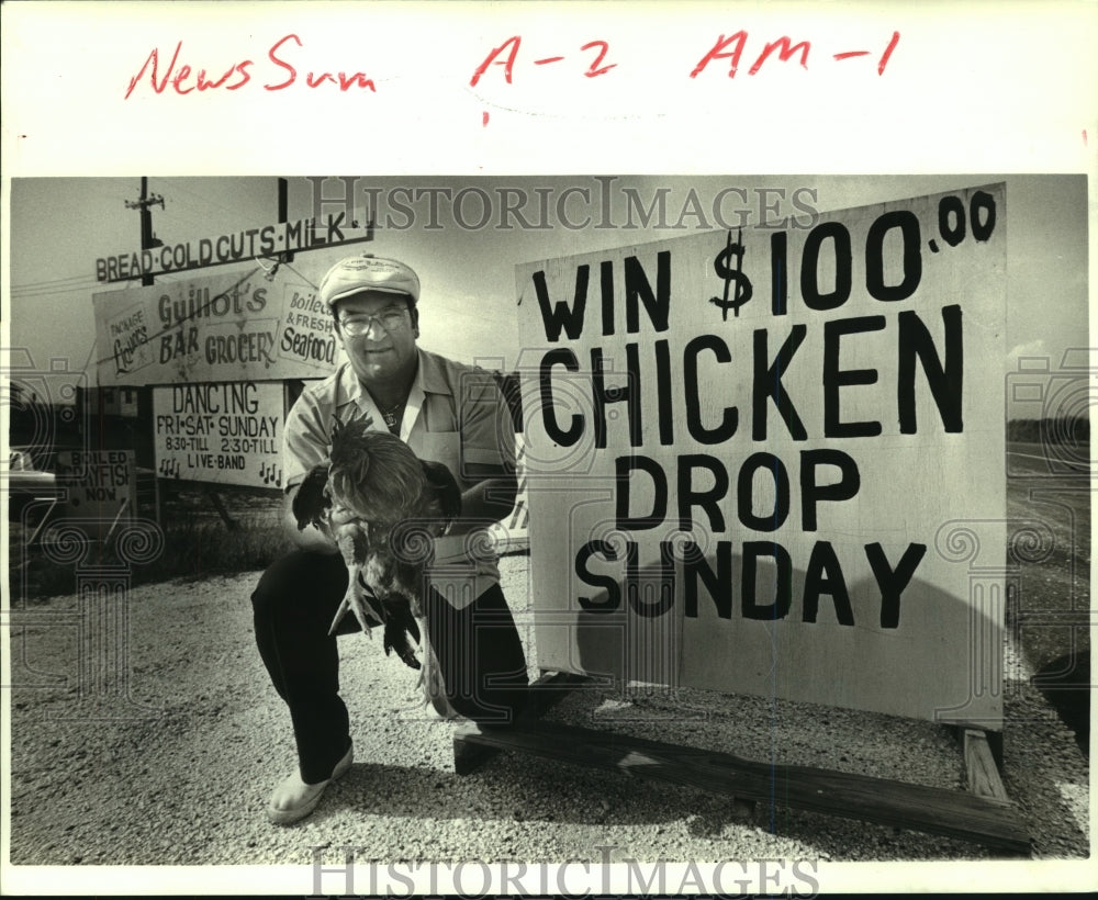 1986 Press Photo Benny Guillot in front of his sign with chicken - nob22264 - Historic Images