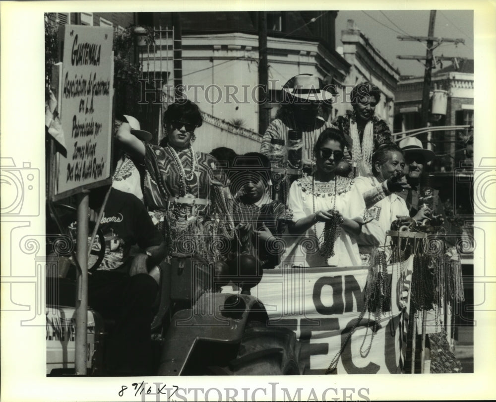 1991 Press Photo Guatemala float members in the Hispanidad Parade toss beads - Historic Images