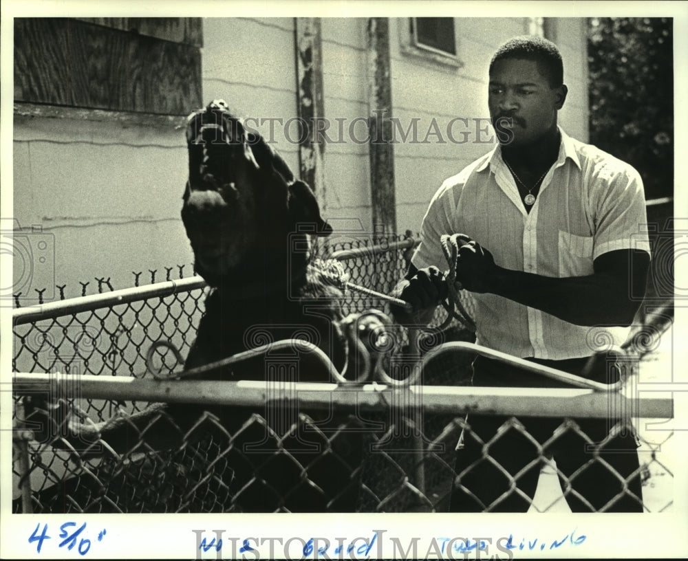 1987 Press Photo Jules McClain holds his lunging dog, Rambo - Historic Images