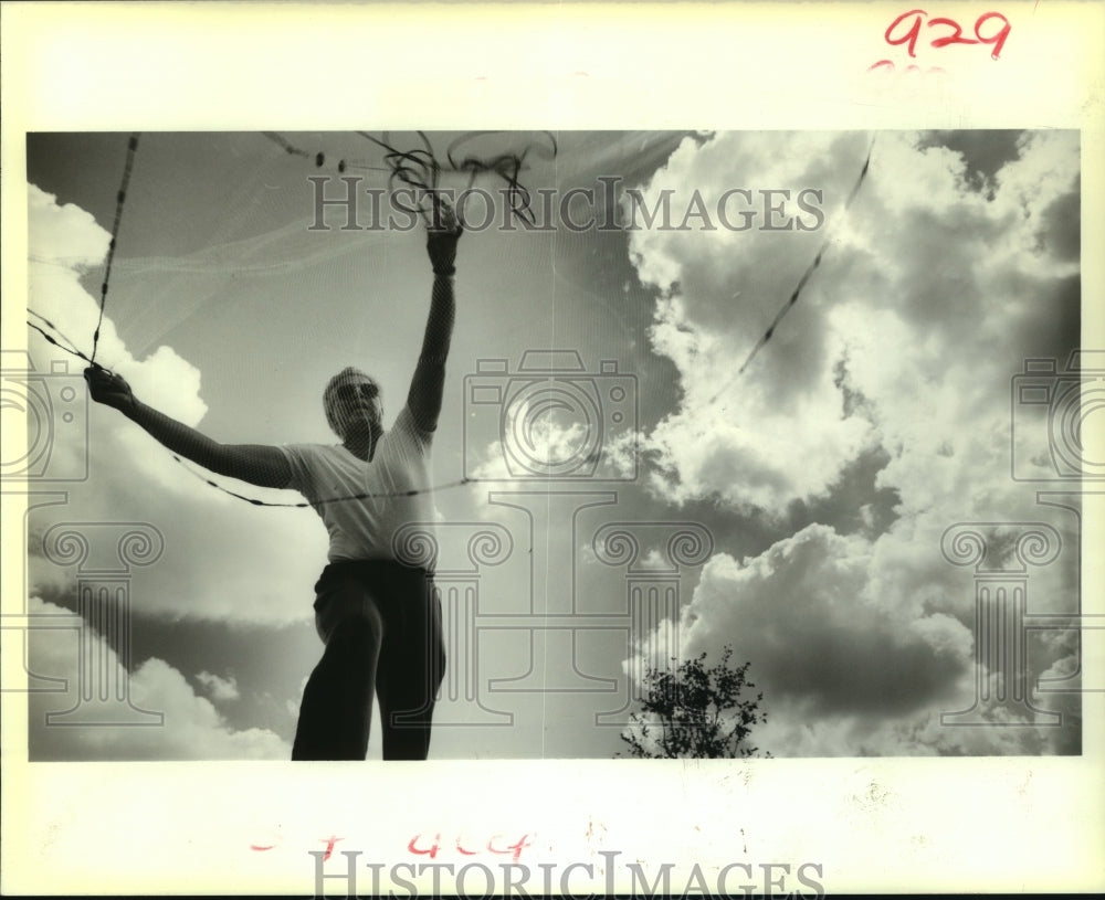 1988 Press Photo Bily Gueno of New Orleans casts a net into Lake Pontchartrain - Historic Images