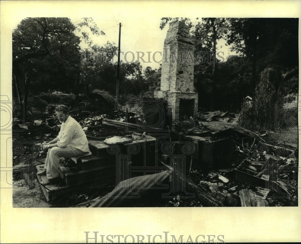 1995 Press Photo Melvin Guerra sits on the burnt remains of his house - Historic Images