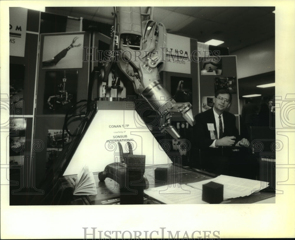 1996 Press Photo Wesley Gerriets of Schilling Robotic Systems shows off a robot - Historic Images