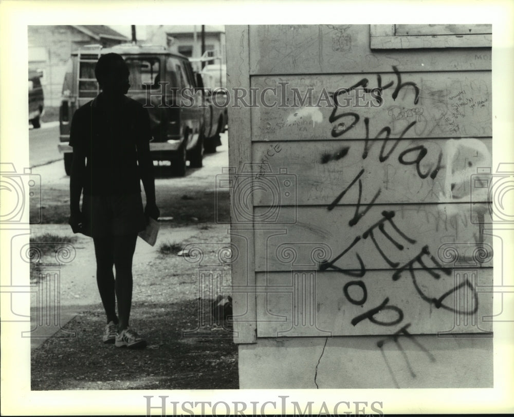 1990 Press Photo A man read the graffiti on the wall of an abandoned house - Historic Images