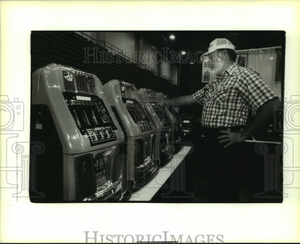 1994 Press Photo Jim Cooper puts quarter in an old slot machine - Historic Images