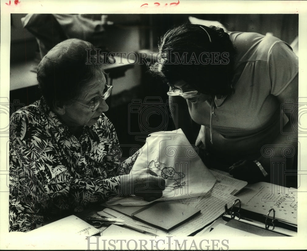 1986 Instructor Molly Lent helps Shiela Williams with a needle point - Historic Images