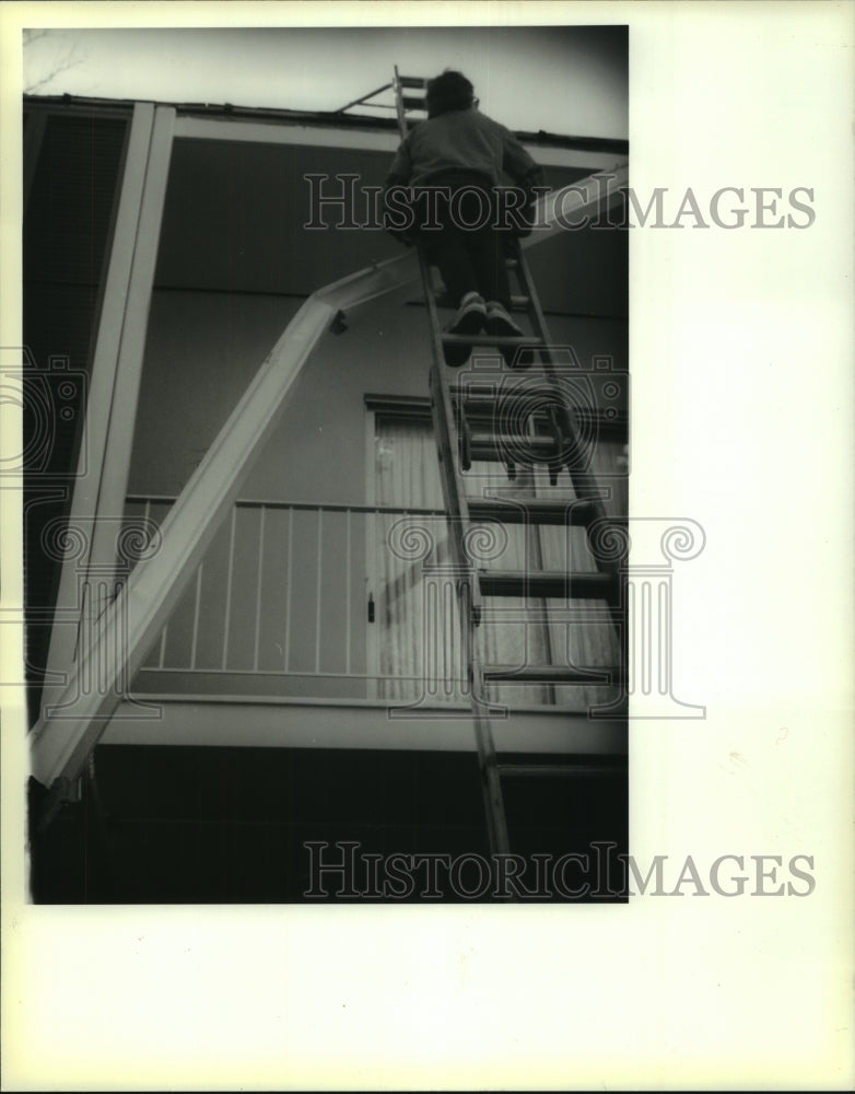 1991 Press Photo A worker checks the section prior to gutter installation - Historic Images