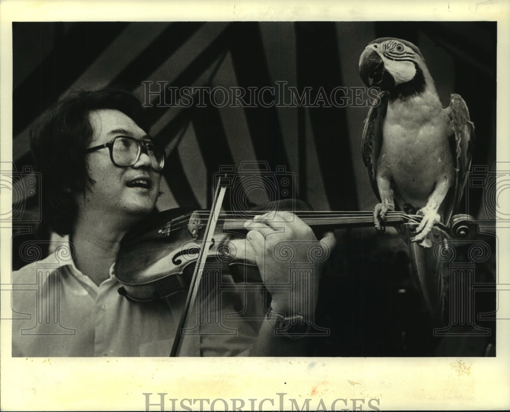 Press Photo New Orleans Philharmonic violinist Henry Lee plays to a macaw - Historic Images