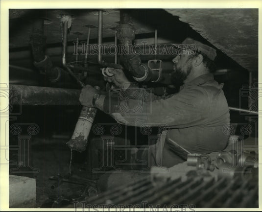 1990 Press Photo Orleans School Board plumber Wayne Guillot Sr. makes repairs - Historic Images