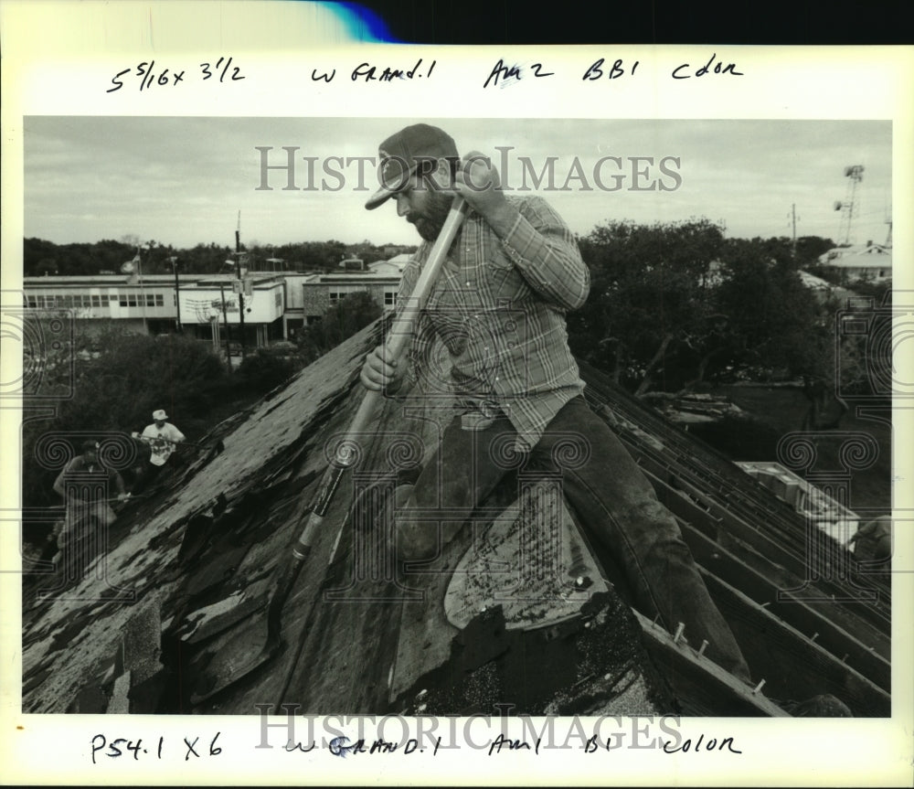 1994 Press Photo Louis Brunet scrapes roofing shingles from tornado damaged home - Historic Images