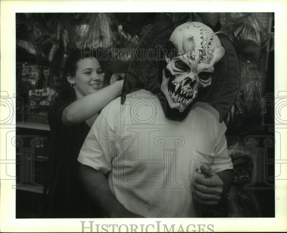 1994 Press Photo Jessica Dufrene helps fiancee pick mask for a Halloween dance. - Historic Images