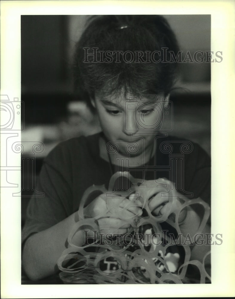 1990 Press Photo Melissa Puglia ties &quot;six-pack&quot; plastic together for tote bags. - Historic Images