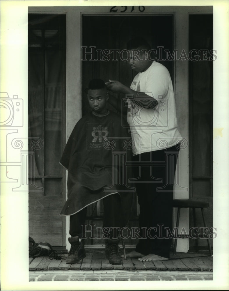 1993 Press Photo Kip Joseph clips Roosevelt Carter&#39;s hair on Jena Street porch - Historic Images